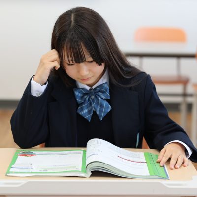 World-Class academics and education being taught at One World International School. A secondary school student read a textbook and thinks deeply (thinking)